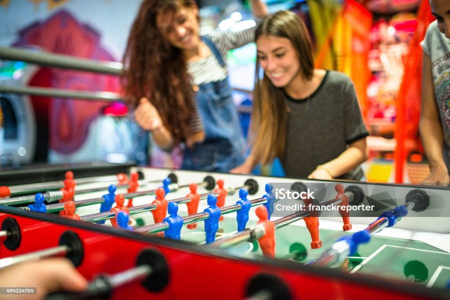 friends playing foosball at the arcade game